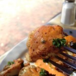 Piece of cauliflower on fork with tahini sauce