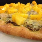 Homemade pistachio pesto pizza on a cutting board