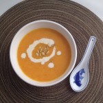 Bowl of Creamy Roasted Carrot Soup topped with pine nuts