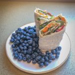 Wrap sandwich on a plate with blueberries