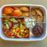 Bento box filled with fruit, crackers and vegetables