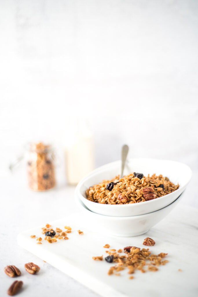 Bowl of granola with some scattered on the counter