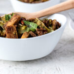 Close up white bowl filled with tofu and brussels sprouts