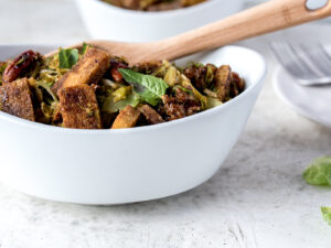 Close up white bowl filled with tofu and brussels sprouts