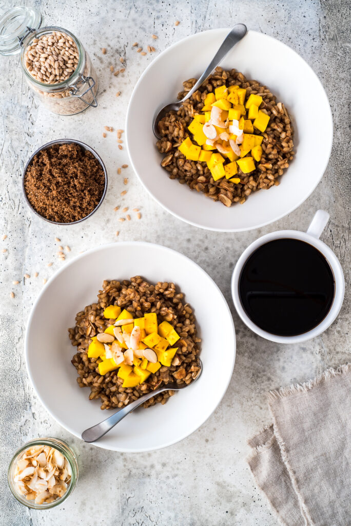 Top down view of two bowls of hot cereal and a cup of coffee