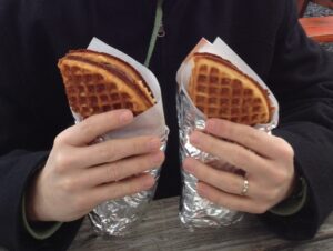 Person holding two waffle sandwiches