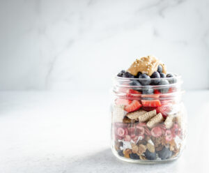 Mason jar filled with layers of fruit and cereal