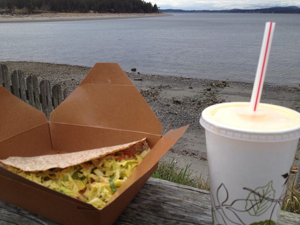 Wrap and drink in to go containers on a wall near the water