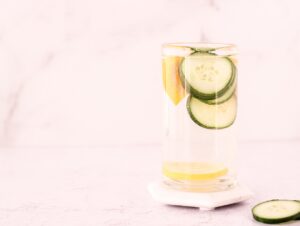 Glass of water with lemon, cucumber and orange slices in it