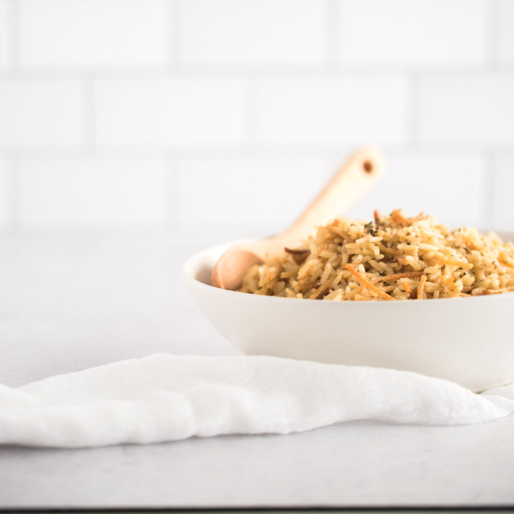 White bowl filled with rice and a spoon