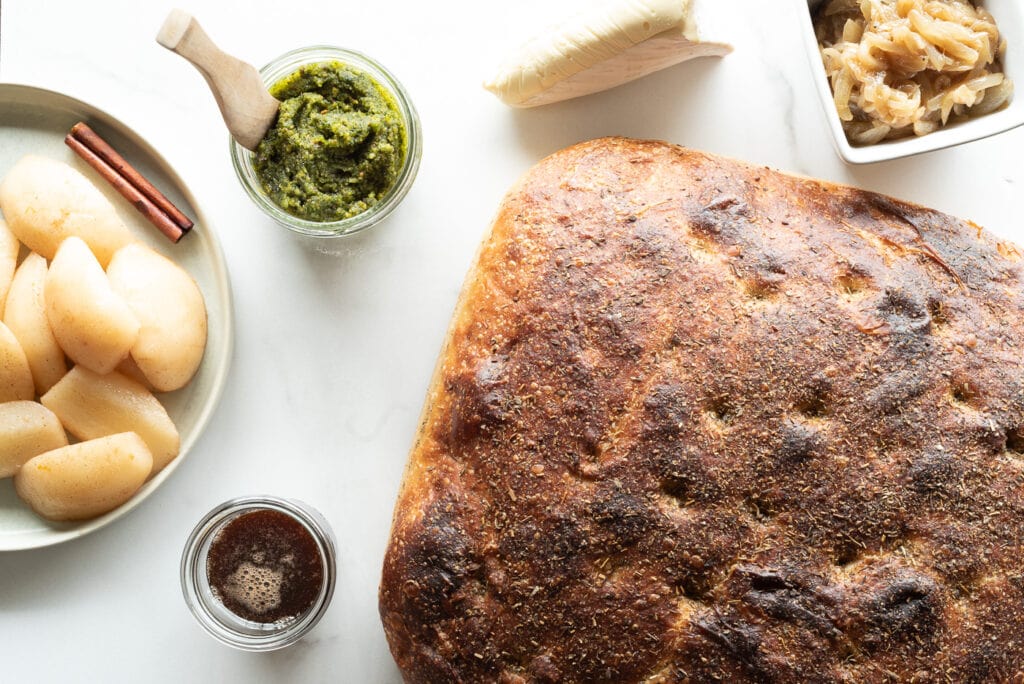 Top down view of bread, pesto, pears and brie