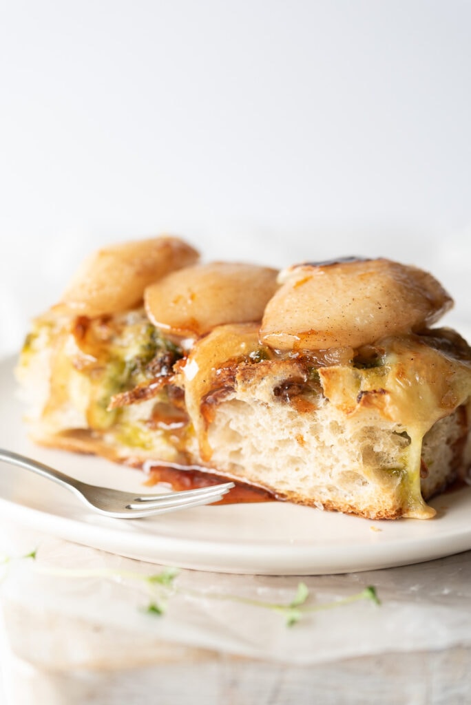 Close up of focaccia on a plate covered in pears and cheese