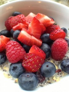 Raspberries, blueberries and strawberries with Holy Crap Cereal in bowl