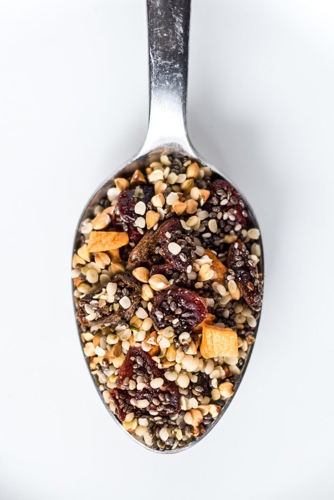 Close up on spoon full of seeds and dried fruit cereal