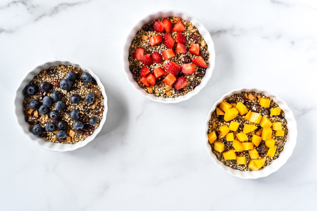 Three bowls of cereal with fruit