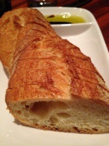 Sliced baquette on platter with olive oil and balsamic vinegar