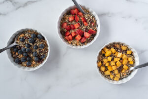 Three bowls of cereal with fruit