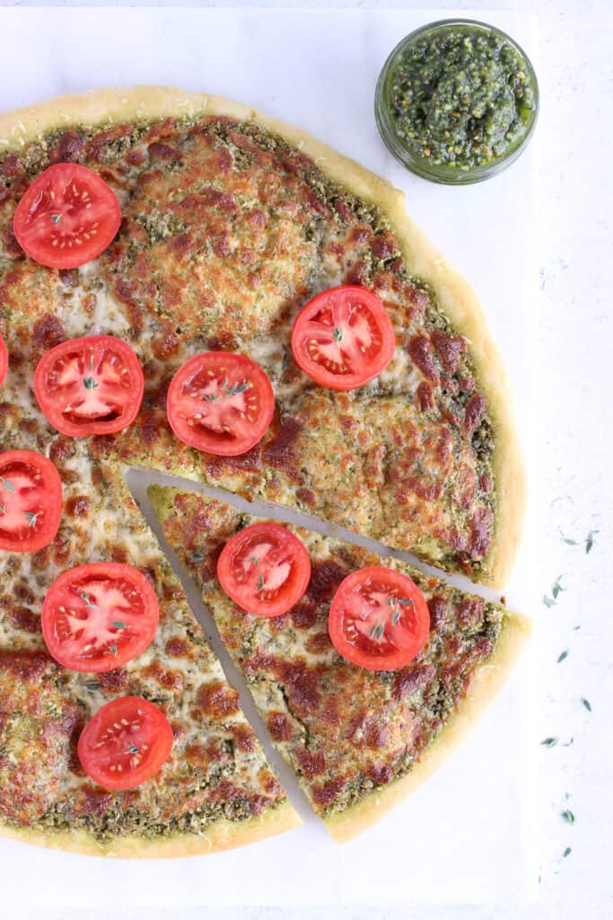 Top down view of a pizza with tomatoes slices on top