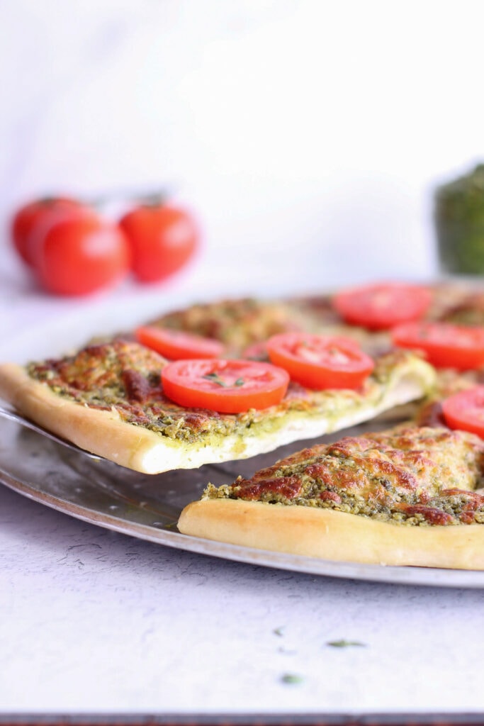 A slice of pizza being lifted out of the whole pizza