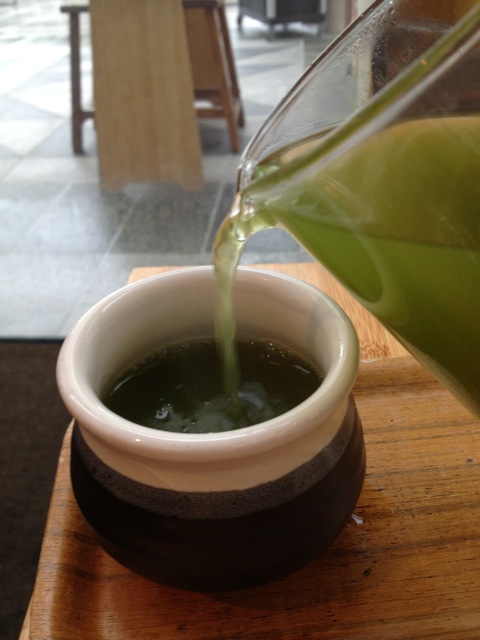 Green tea being poured into a cup