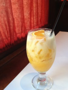 Orange and vanilla drink in a stemmed glass on the table