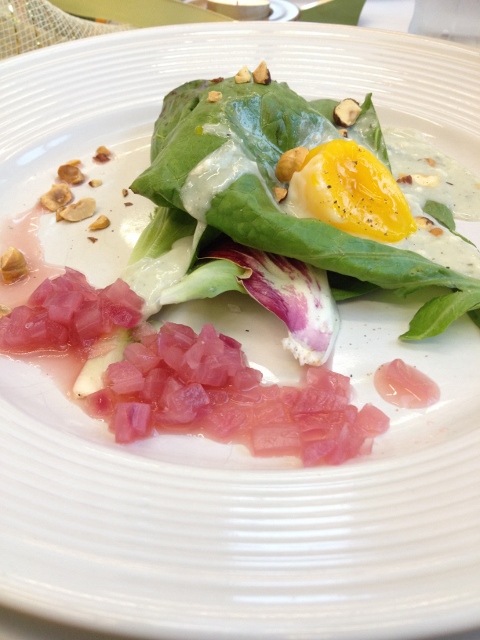 Lettuce, onions, and egg yolk salad on a white plate