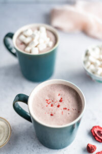 Two mugs of strawberry milk with marshmallows on top