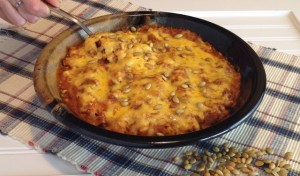 Pan of baked hominy covered in cheese