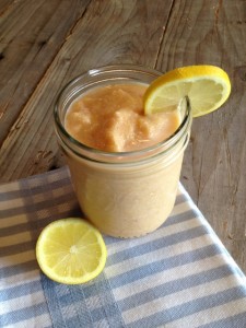 Peach smoothie in a mason jar with sliced lemon