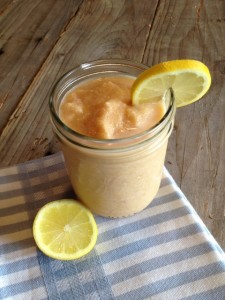 Peach smoothie in a mason jar with sliced lemon