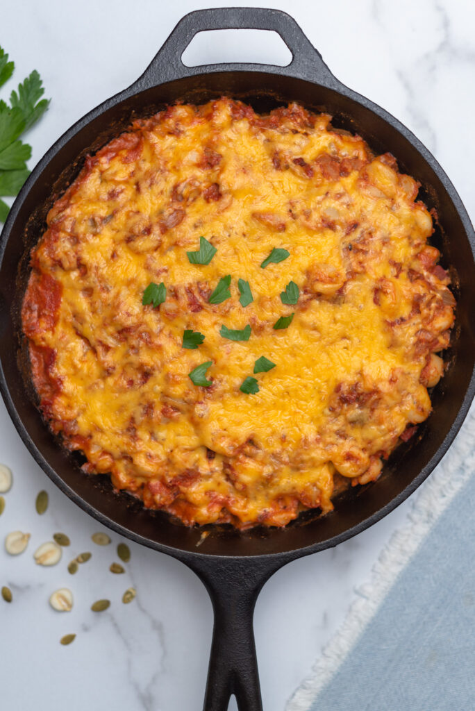 Top down pic of a cast iron skillet filled with cheese and posole