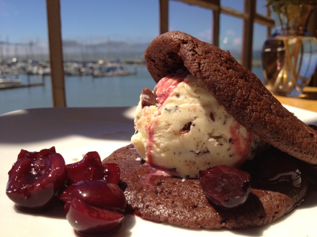 Chocolate cherry ice cream sandwich with two chocolate cookies, ice cream and fresh cherries