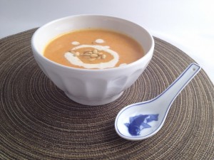 Bowl of Creamy Roasted Carrot Soup garnished with pine nuts