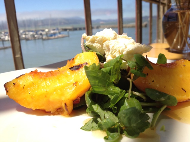 Grilled peaches served with cheese, honey and watercress