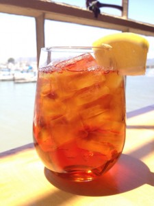 Refreshing glass of mango iced tea garnished with lemon