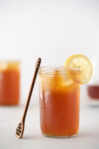 Glass of iced tea with lemon and a honey server