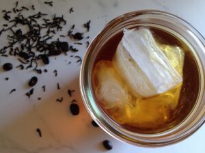 Top down shot of a glass of iced tea and some scattered loose tea