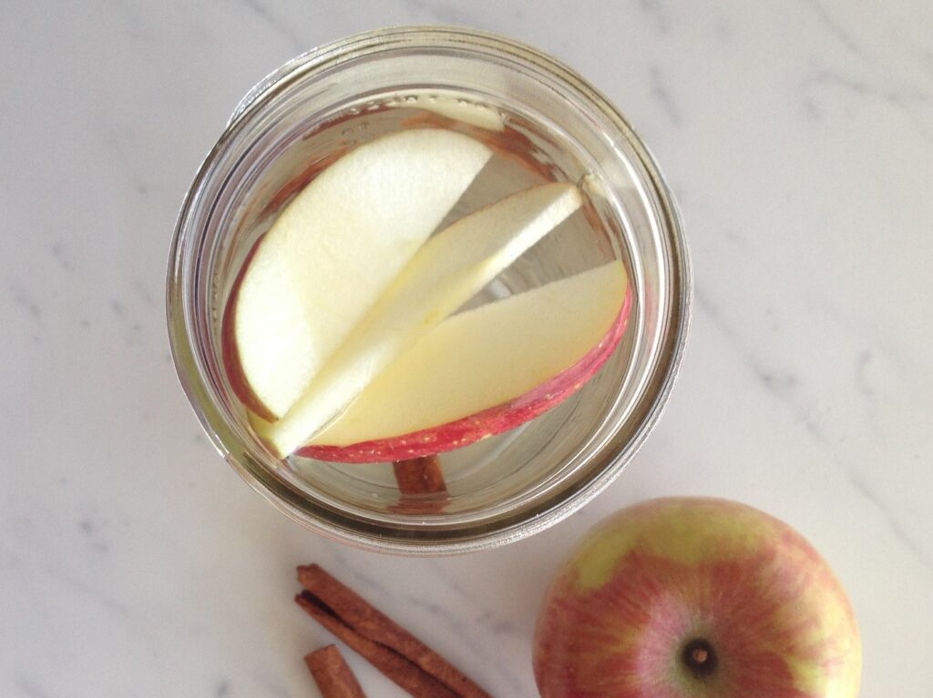 Top down view of canning jar with water and apple slices
