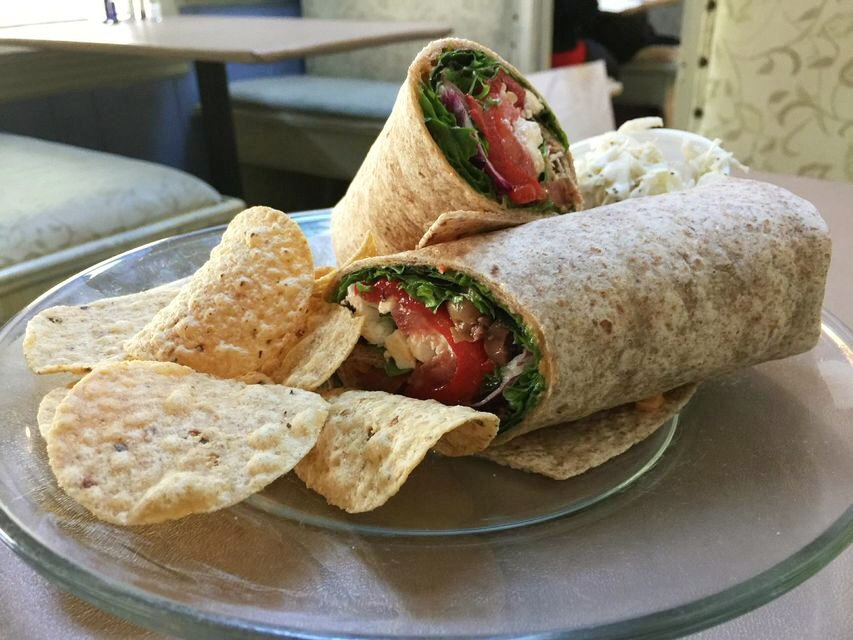 Veggie wrap on a plate with chips