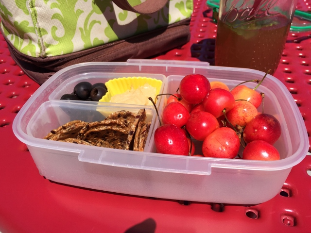 Cherries, crackers, olives, hummus bento lunch