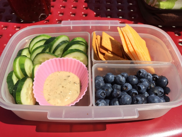 Cucumber, goddess dressing, cheese, crackers, blueberries bento lunch