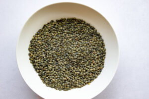 Top down view of white bowl filled with green lentils