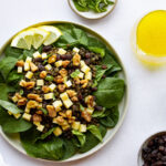 Top down view of a plate of lentil salad and bowls of toppings