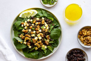 Top down view of a plate of lentil salad and bowls of toppings