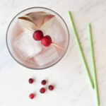 Top down of glass with cranberry garnish and two straws