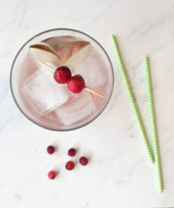 Top down of glass with cranberry garnish and two straws