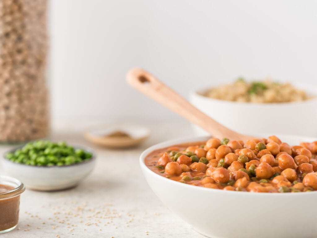 Bowl of garbanzos and peas in tomato sauce