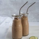 Two small jars full of chocolate smoothie with straws