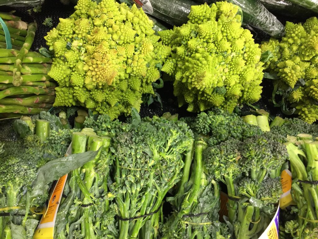 Close up view of broccoli raab and romanesco in the produce department