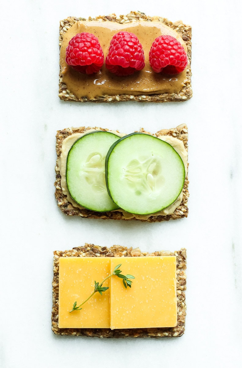 three crackers with toppings in a row